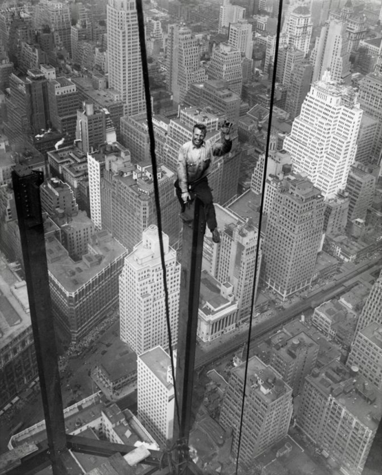 O operário Carl Russell senta a 400 metros do nível da rua acenando para o fotógrafo durante a construção do Empire State Building, em 18  de setembro de 1930.